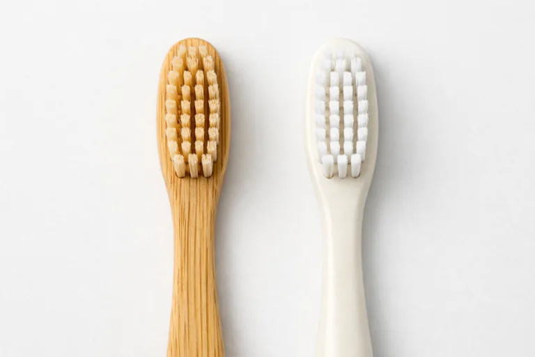 This image presents both a bamboo and a bioplastic toothbrush next to each other, highlighting their material differences and eco-friendly design.