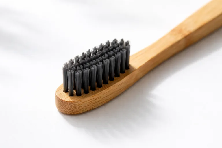 A detailed visual featuring a sustainable bamboo handle paired with charcoal infused bristles, showcasing the texture and quality contrast.