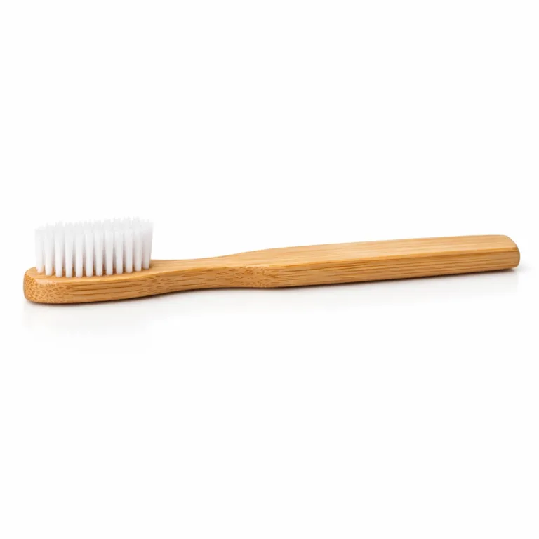 A bamboo adult soft bristle toothbrush offering a beveled edge along its natural bamboo handle, designed for enhanced comfort and grip. The brush maintains a straight traditional shape with soft white bristles.