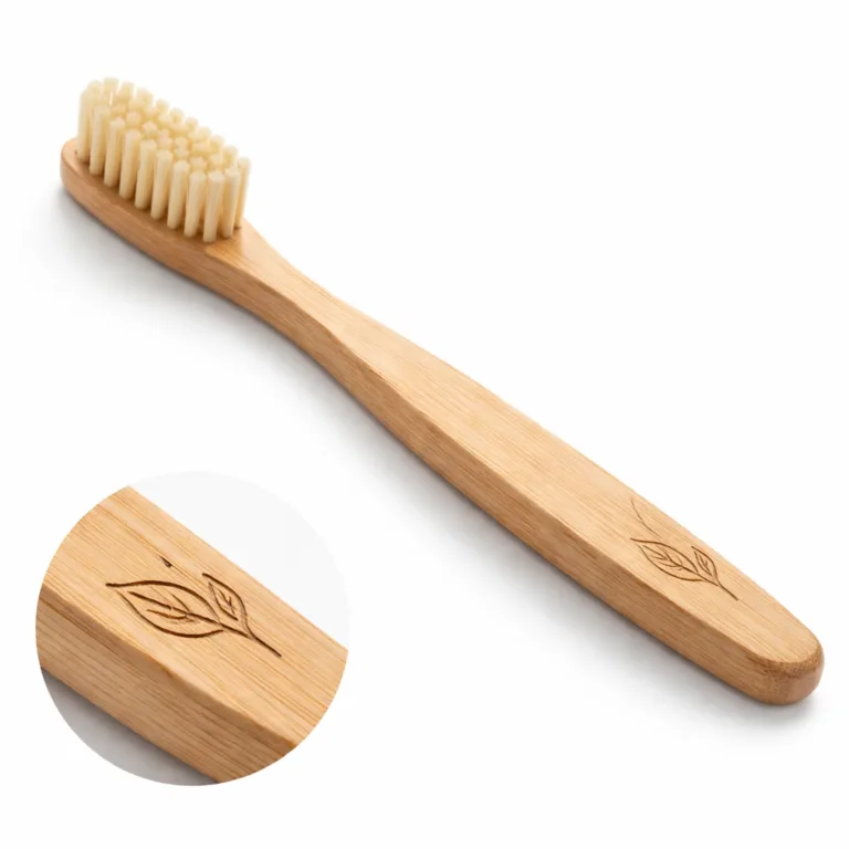 This bamboo toothbrush variant features a handle with subtle beveled edges and the laser-engraved logo placed on the side, highlighting both ergonomic design and artisanal engraving against a pure white background.