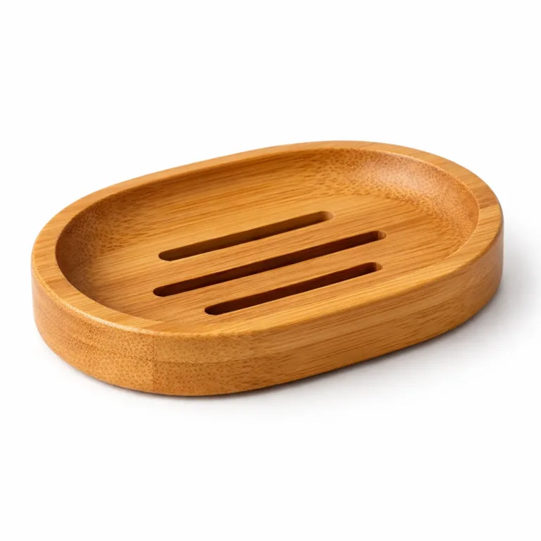 Oval bamboo soap dish for shampoo bar, matte-oiled for a smooth non-glossy look, designed with a gently elevated rim for water control and linear drainage slots. Studio photography captures wood texture and craftsmanship details.