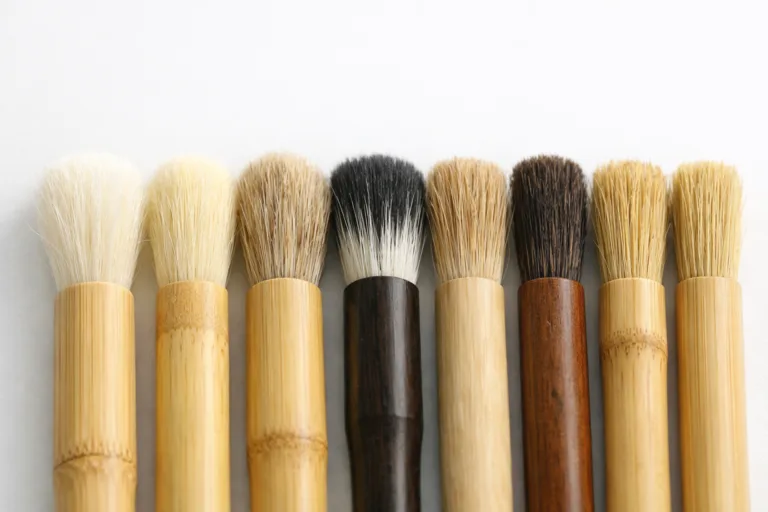 A clean lineup of bamboo and wood brushes showing soft, medium, and hard bristle firmness options, captured for a professional manufacturing context.