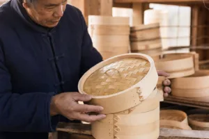A realistic close-up showing bamboo steamer assembly quality, rim craftsmanship, and lid fit during manufacturing.